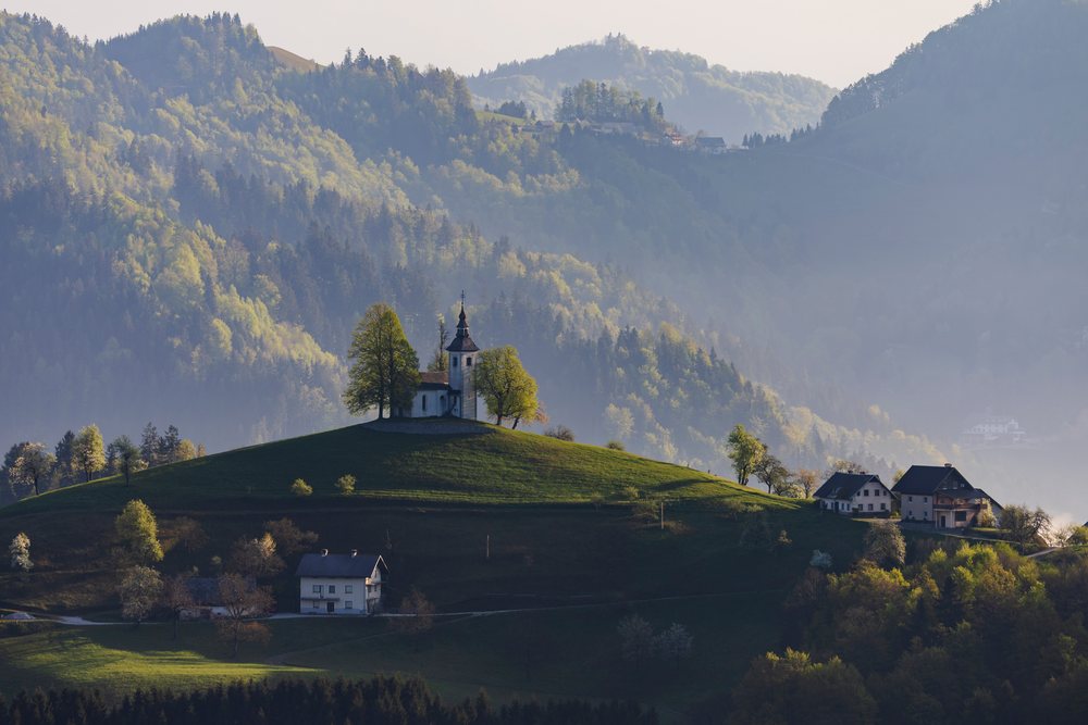 St Thomas's Church sits atop a green hill, landscape, cityscape, Škofja Loka, Slovenia.