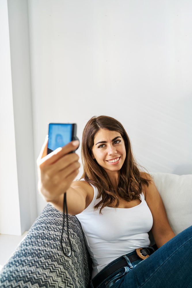 A young white woman enjoys taking a selfie indoors