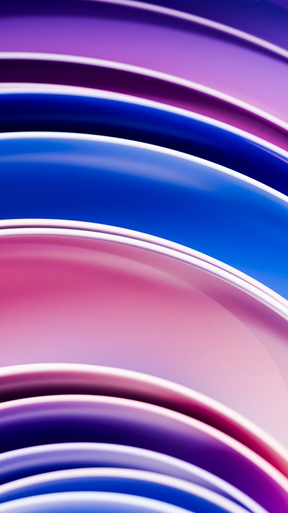 Abstract smooth curved waves with gradient purple, blue, and pink colors in a modern digital illustration.