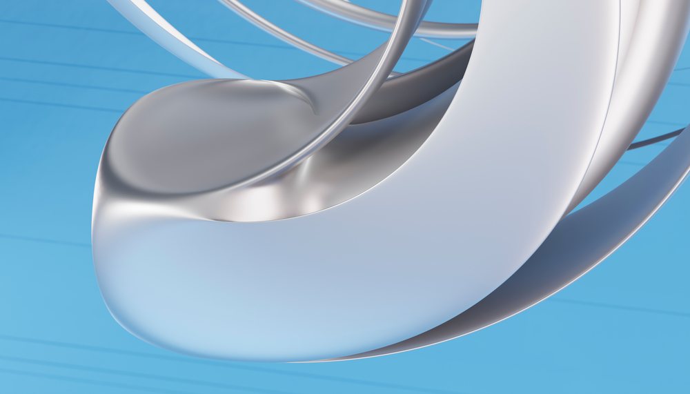 Metallic abstract sculpture featuring smooth curved forms set against a blue backdrop.
