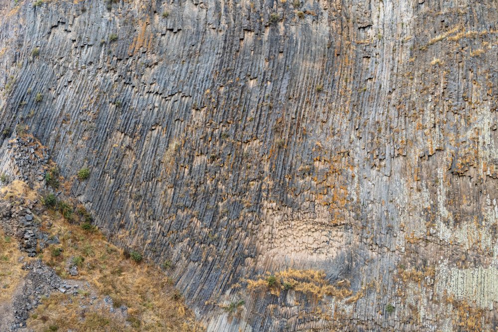 Vertical basalt columns form striking rock cliffs below Garni Temple beside the Azat River in Armenia's Garni Gorge.