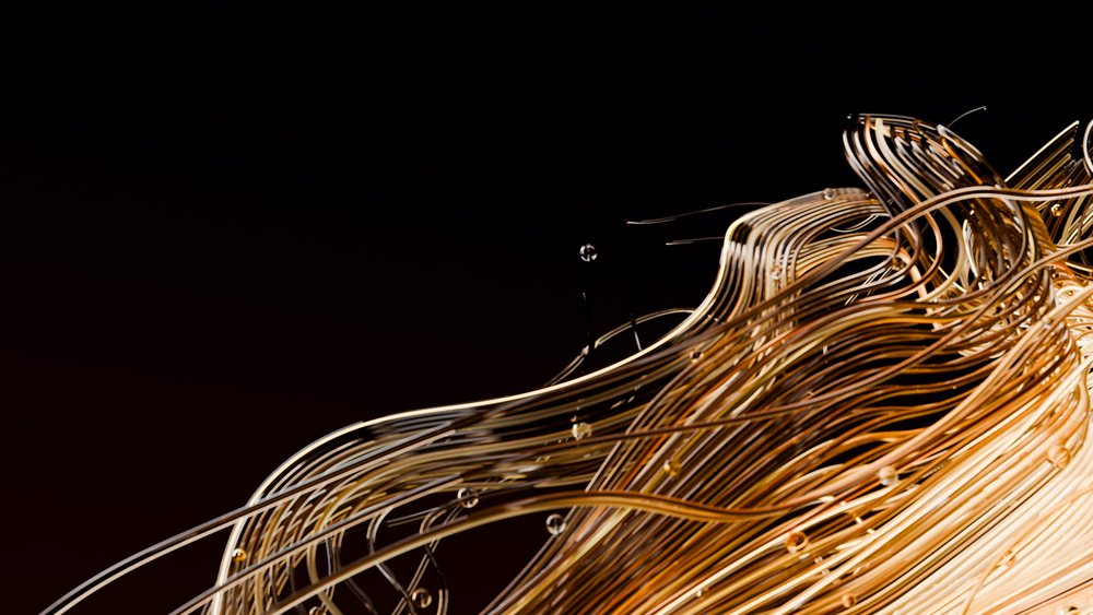 Flowing golden wires and transparent bubbles form an abstract decorative pattern on a dark background.