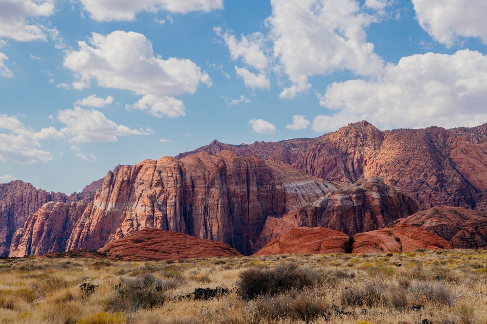Red rock formations and desert landscape under a partly cloudy sky, Cathedral Gorge State Park, Nevada, USA.