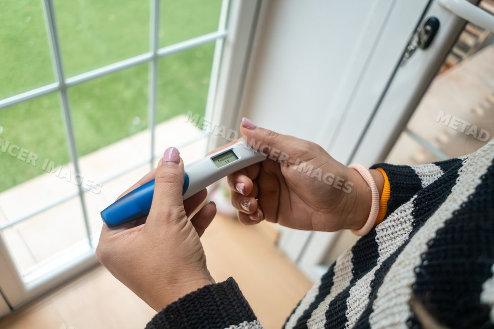 A white woman holds a digital pregnancy test