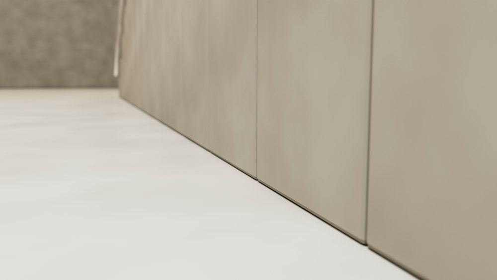 Modern minimalist interior corner with smooth beige cabinets, light floor, and soft shadows.
