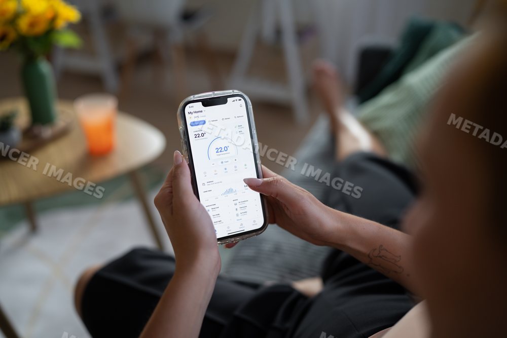 White Person adjusting home temperature with mobile app in living room