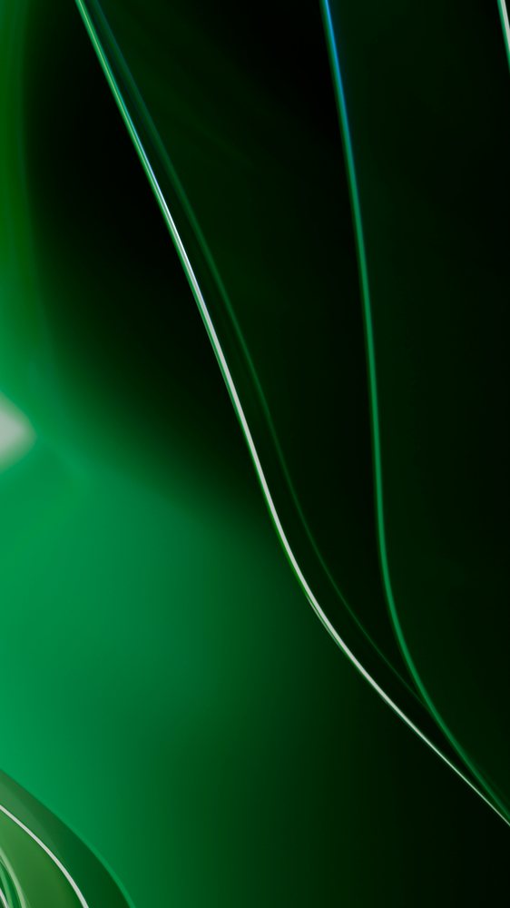 Curved green glass surfaces with reflections creating an abstract artistic design.