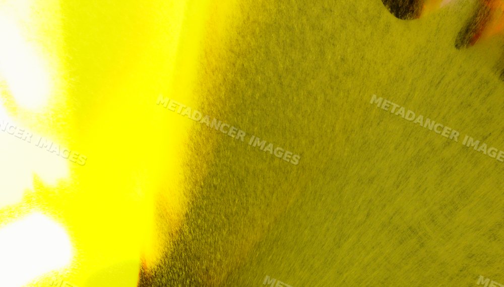 Close-up view of yellow spray paint particles creating a textured