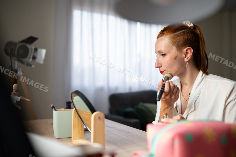 A white woman applies facial makeup at home in Galicia, spain