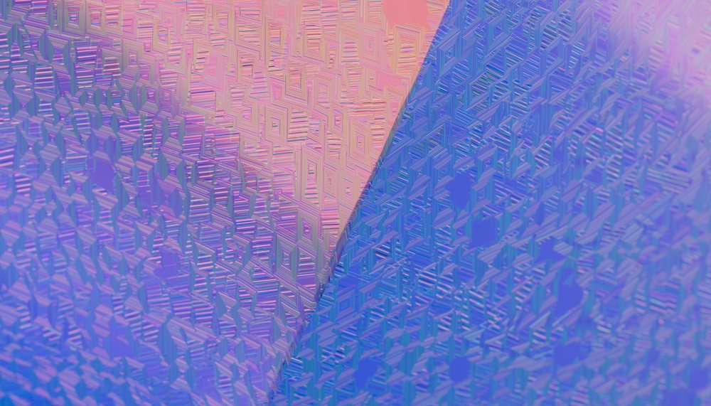 Reflective surface with a geometric pattern of triangular shapes in pink and blue hues creating an abstract texture.