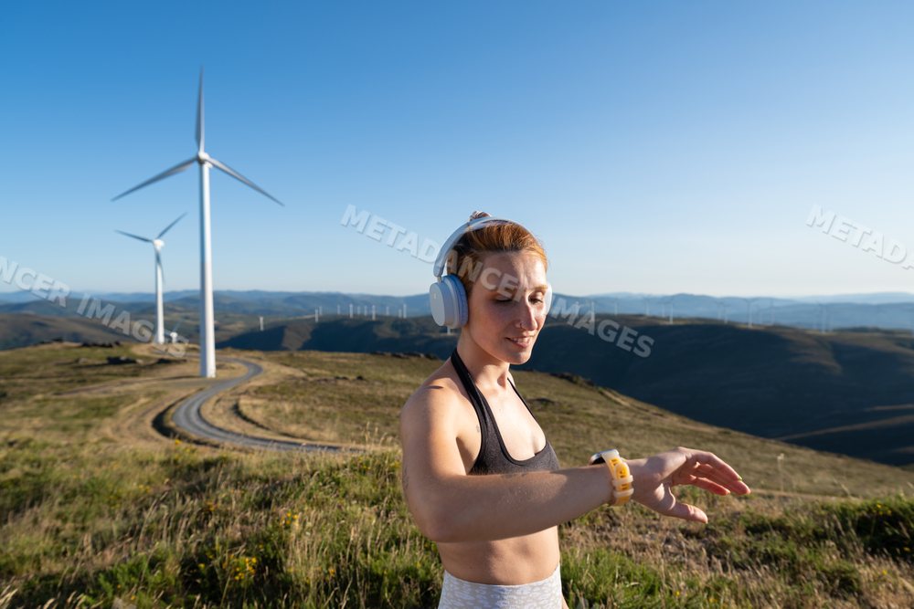 A white woman checks her fitness tracker during outdoor workout