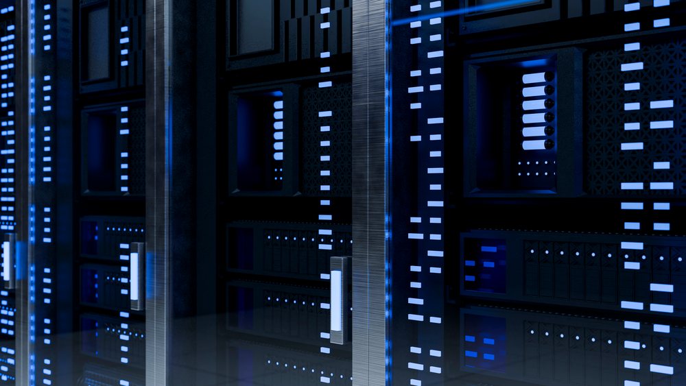 Computer server racks with illuminated blue LED lights reflecting on the floor in a data center environment.
