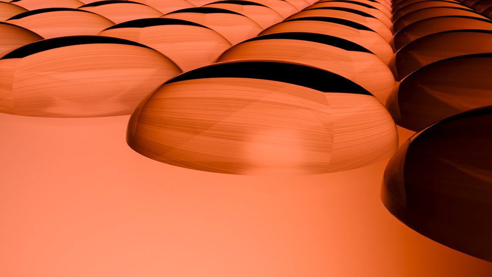 Orange 3D rendered spheres arranged in a pattern on a smooth orange background.