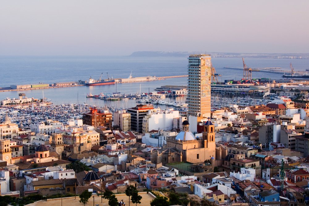 Sunset view of Alicante harbor with boats, yachts, and cityscape along the Mediterranean Sea, Valencia, Spain.