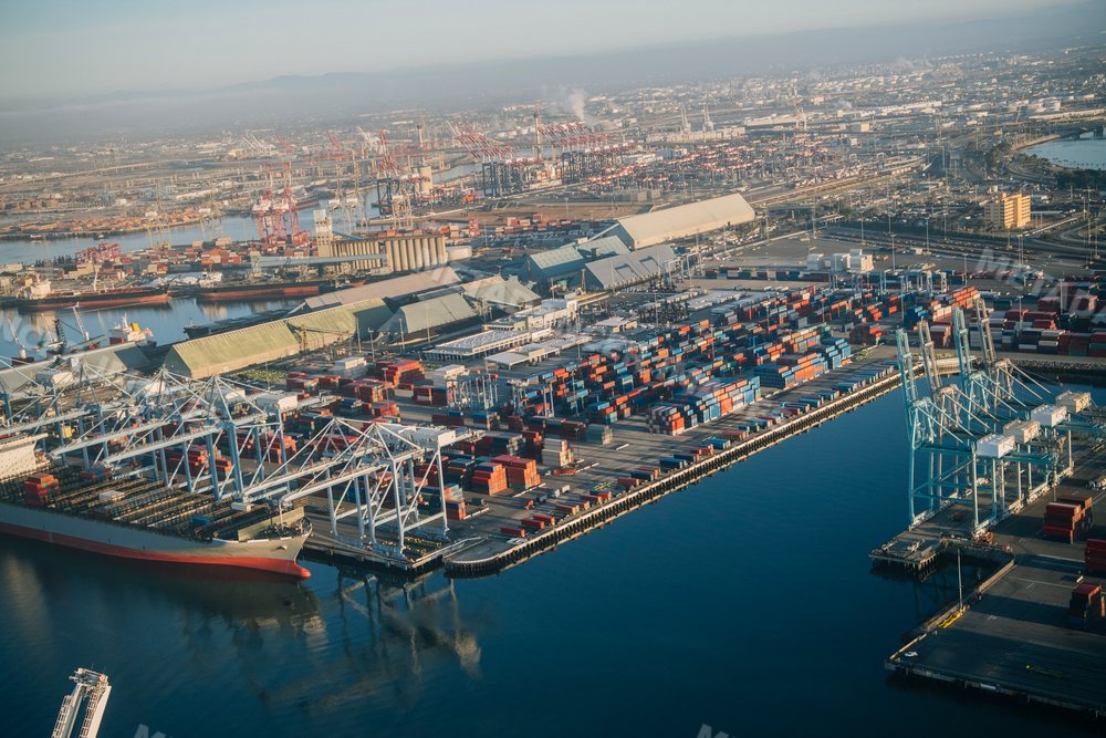 Aerial view of container port with cargo ships and cranes in a beach