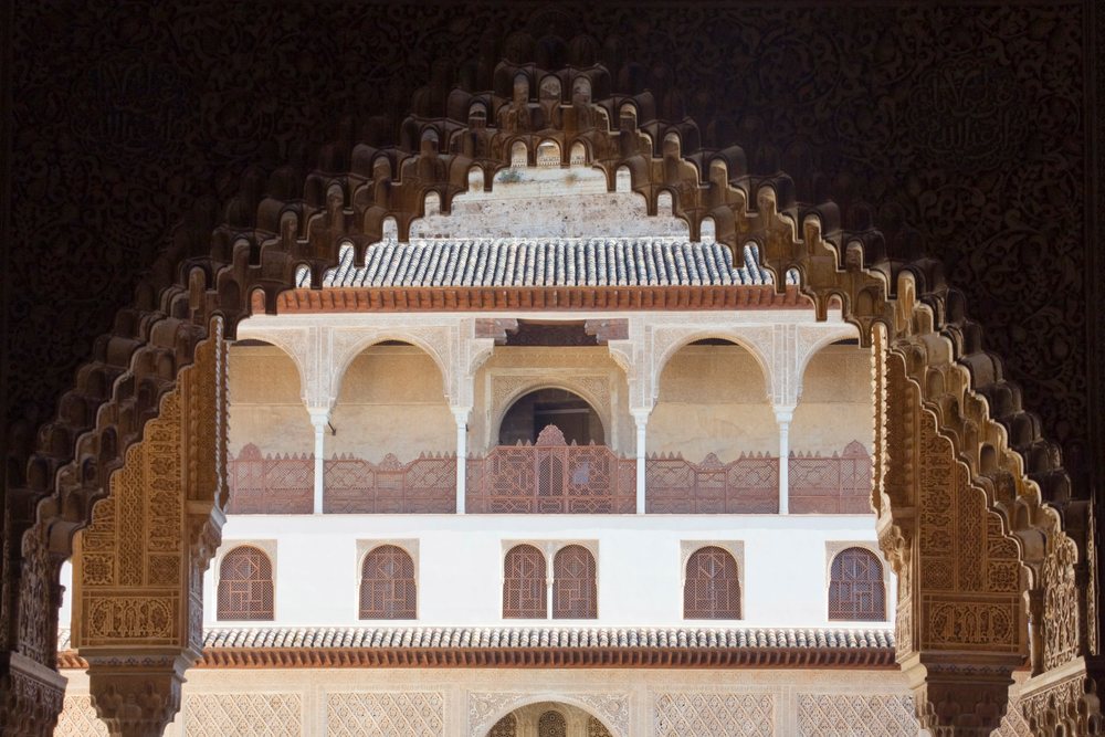 Ornate decorative archway frames the Casa Real building at the Alhambra, Andalucia, Spain.