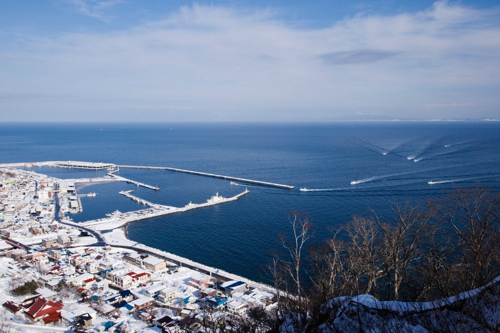Fishing fleet docked in a snow-covered harbor on the Shiretoko Peninsula, Hokkaido, Japan.