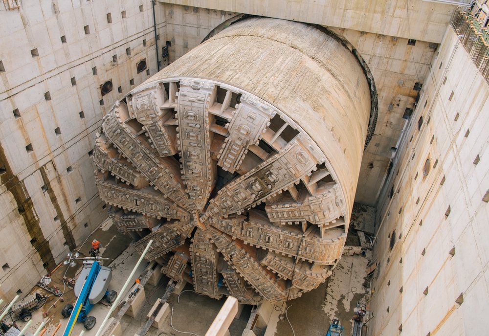 A large tunnel boring machine is positioned inside a deep construction pit for drilling an underground tunnel, USA.