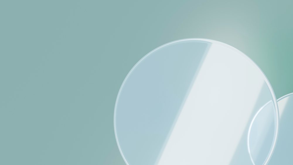 Transparent glass circles reflect light on a smooth blue-green background in a minimalistic studio illustration.