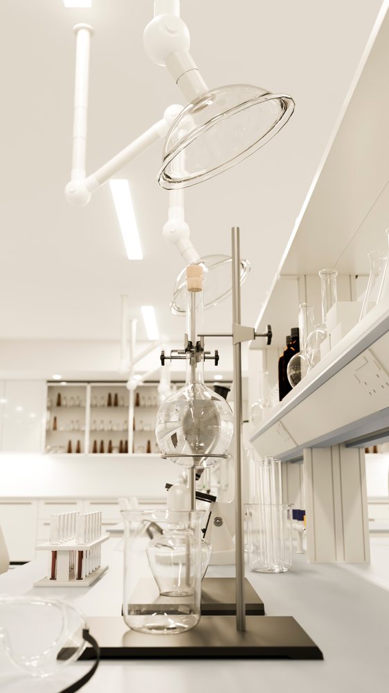 Laboratory with distillation apparatus, test tubes in rack, beakers, and microscope on lab bench in a clean white environment.