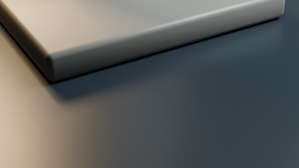 Empty rectangular plate with matte finish on a dark minimalist surface under studio lighting.