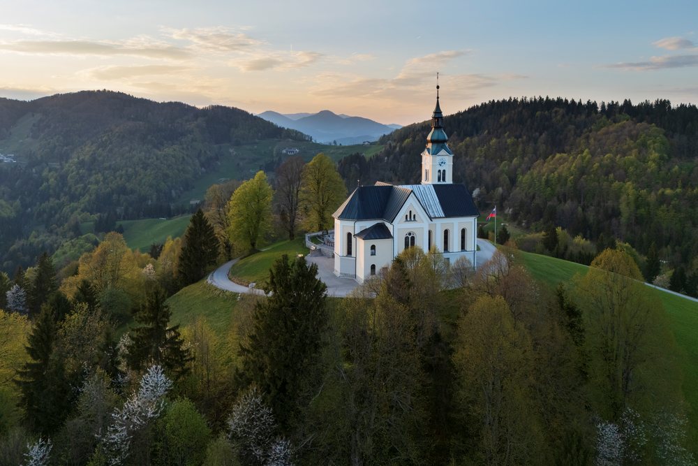 Parish Church of St. Leonard stands atop a forested hill, landscape, cityscape, Polhov Gradec, Slovenia.