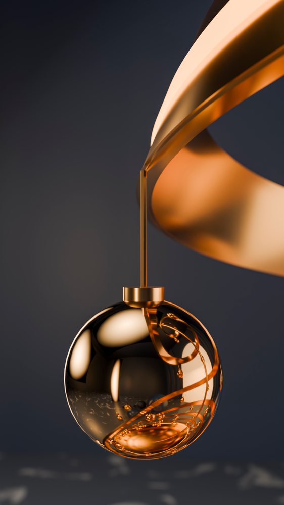 Gold spherical Christmas ornament with curled interior design hanging from a curved gold hook against a dark background.