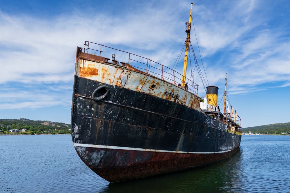 The rusted wreck of the SS Kyle ship rests in calm harbor waters, Newfoundland and Labrador on a clear day, Landscape, Wildlife, Lifestyle, Harbour Grace, Newfoundland & Labrafor, Canada.