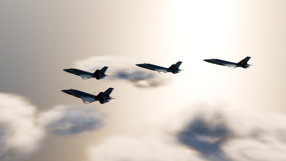 Four fighter jets fly in close formation through clouds during a military aerial operation, defense, war, security.
