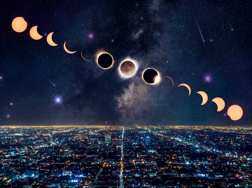 Solar eclipse phases progressing over the Los Angeles cityscape at night with stars and the Milky Way visible, USA.
