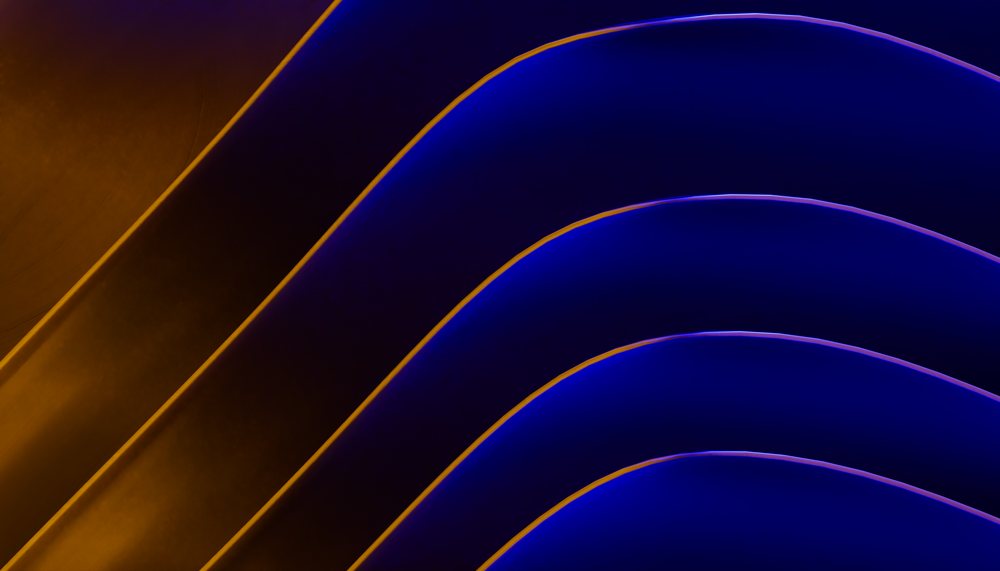 Abstract digital art showing smooth curved flowing blue and yellow waves with a gradient background.