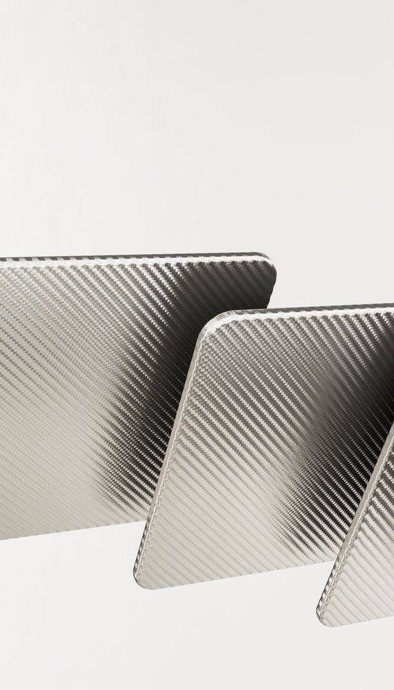 Carbon fiber sheets with woven texture and reflective surface are displayed on a neutral background.