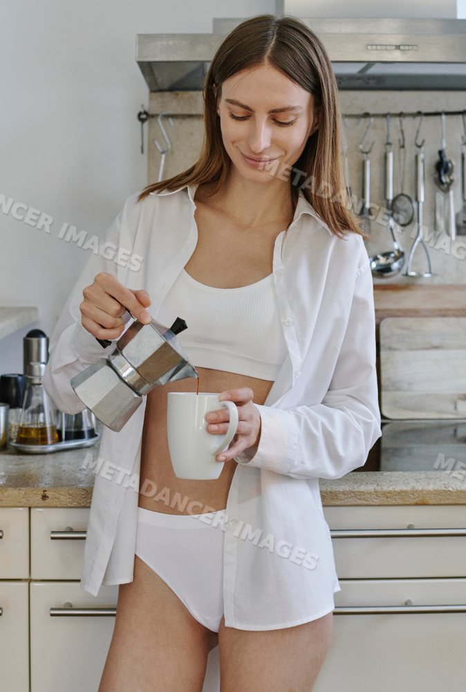 A white woman pours coffee from a stovetop coffee maker into a cup