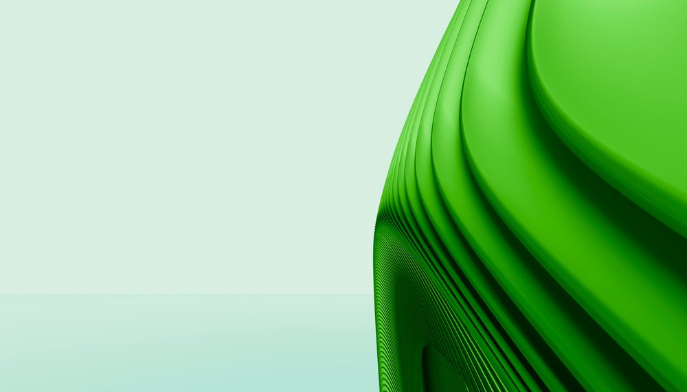 Green abstract curved sculpture with smooth surface on a minimalist pale background.