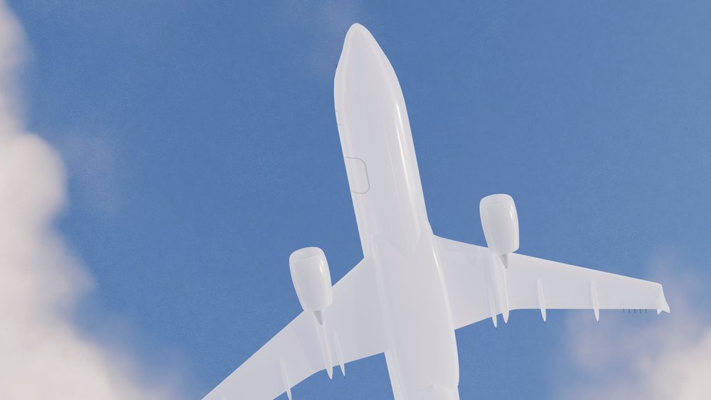 Airplane flying in a clear blue sky viewed from below with visible jet engines.
