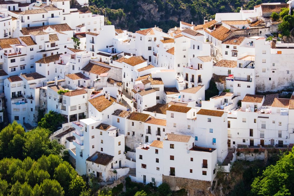 Cluster of white houses with terracotta rooftops on a hillside, Adnalusia, Spain.