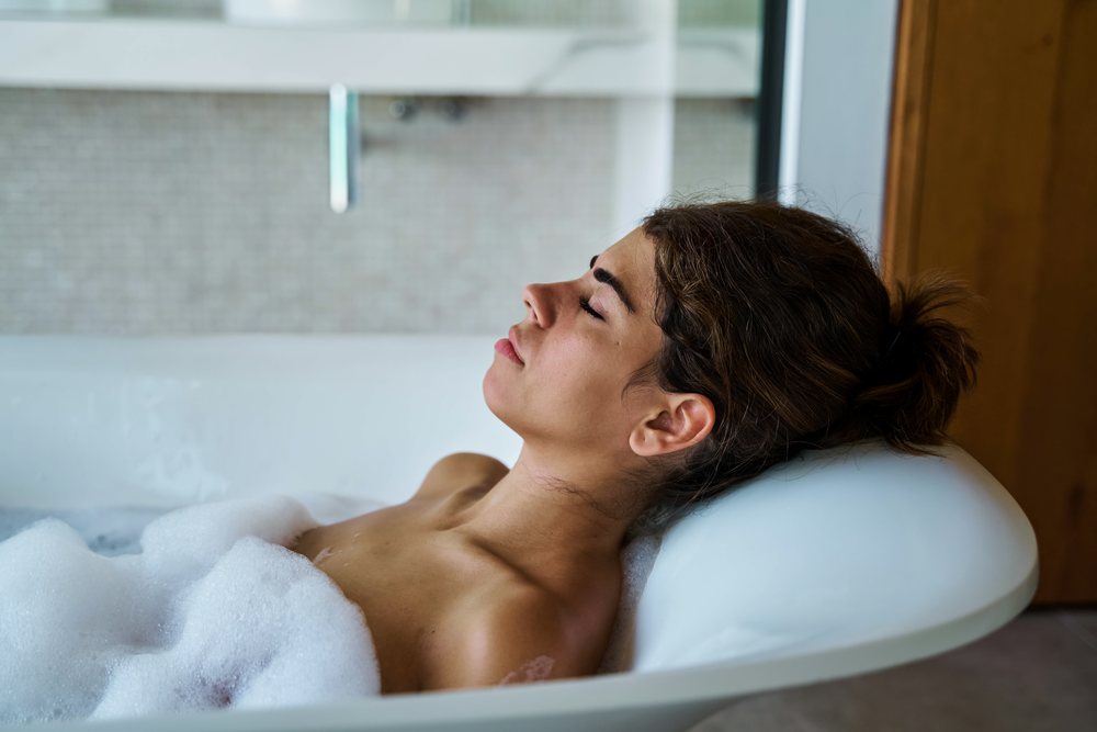 A woman relaxes in a bathtub filled with bubbles, enjoying a peaceful moment of rest in the, Maldives.