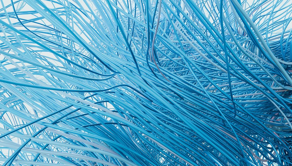 Close-up view of a dense cluster of tangled blue wires creating a complex network.