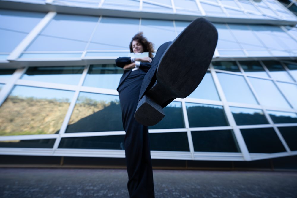 Woman walking confidently in front of a modern glass office building, businesswoman, business trip, Spain, Santiago De Compostela.