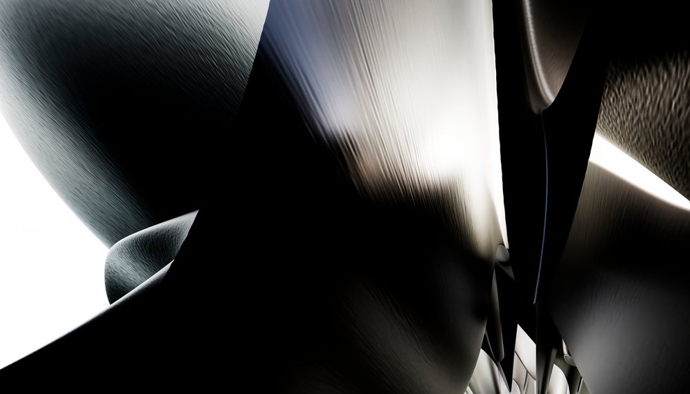Close-up abstract image featuring curved and shiny metallic surfaces with varied light reflections.
