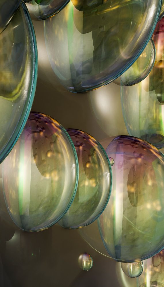 Glass bubbles with colorful reflections and abstract round shapes in a close-up view.