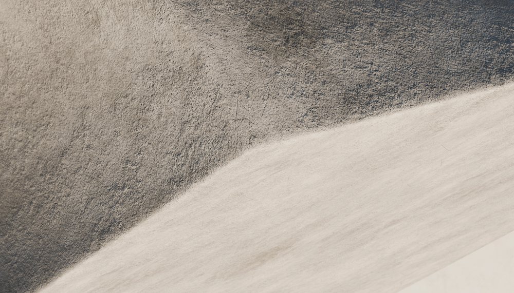 Close-up of a textured light and dark gray concrete wall surface