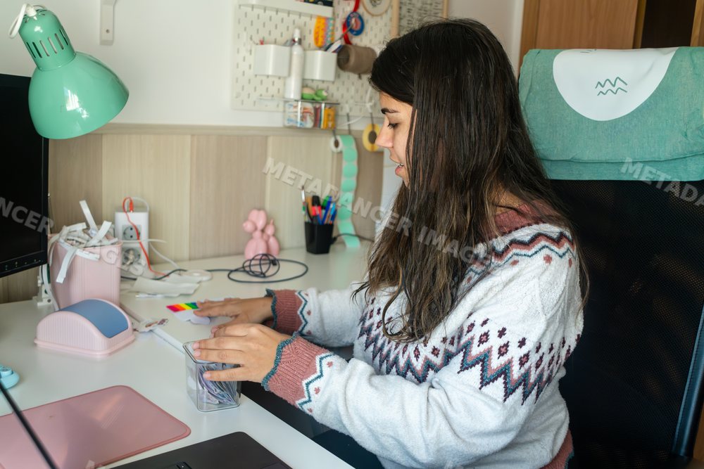 A white woman organizes items on her desk