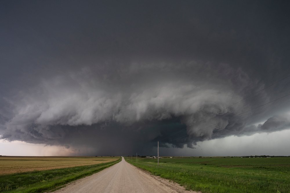 Supercell storm forming over a rural road and agricultural fields, with dark ominous clouds in the sky, Storm Chasing, Weather, Environmental Issues, Enterprise, Kansas, USA.
