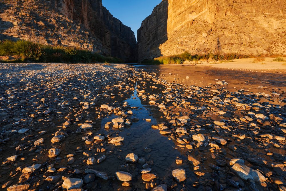 Sunrise illuminates Santa Elena Canyon's rocky riverbed and towering cliffs in Big Bend National Park, landscape, wildlife, Texas, USA.