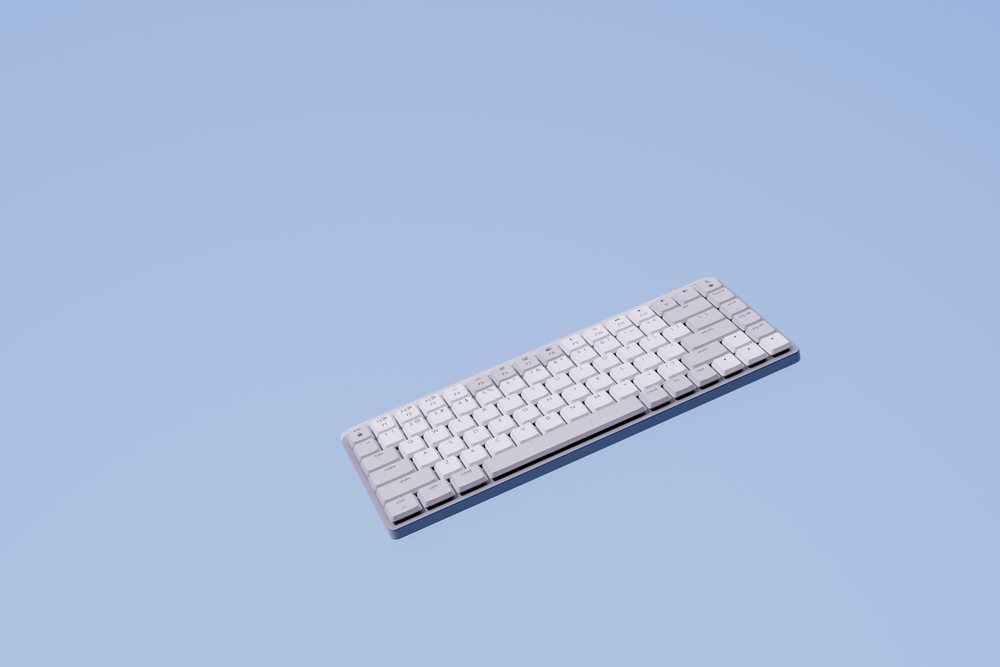 White wireless keyboard isolated on a clean blue background with minimalist design, abstract render background.