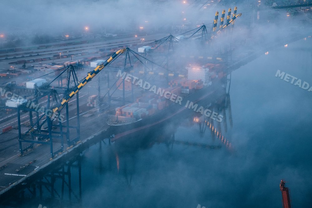 Cargo container ship docked in foggy shipping port at Long Beach