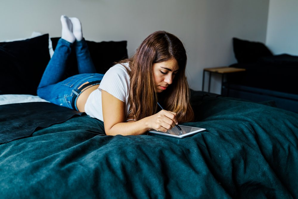 A woman uses a digital pen on a tablet