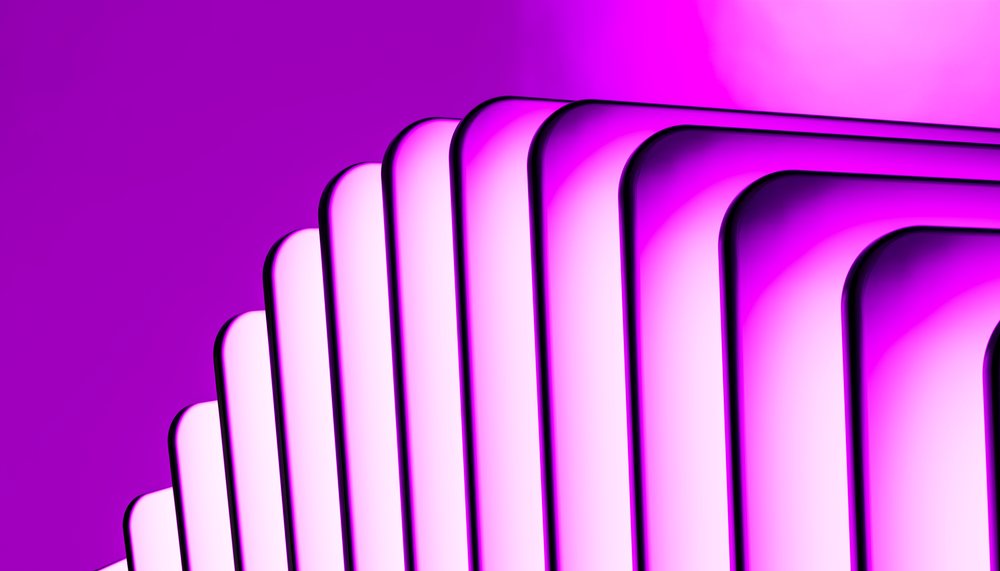 Stack of modern mobile phones arranged in a fan shape on a pink background.