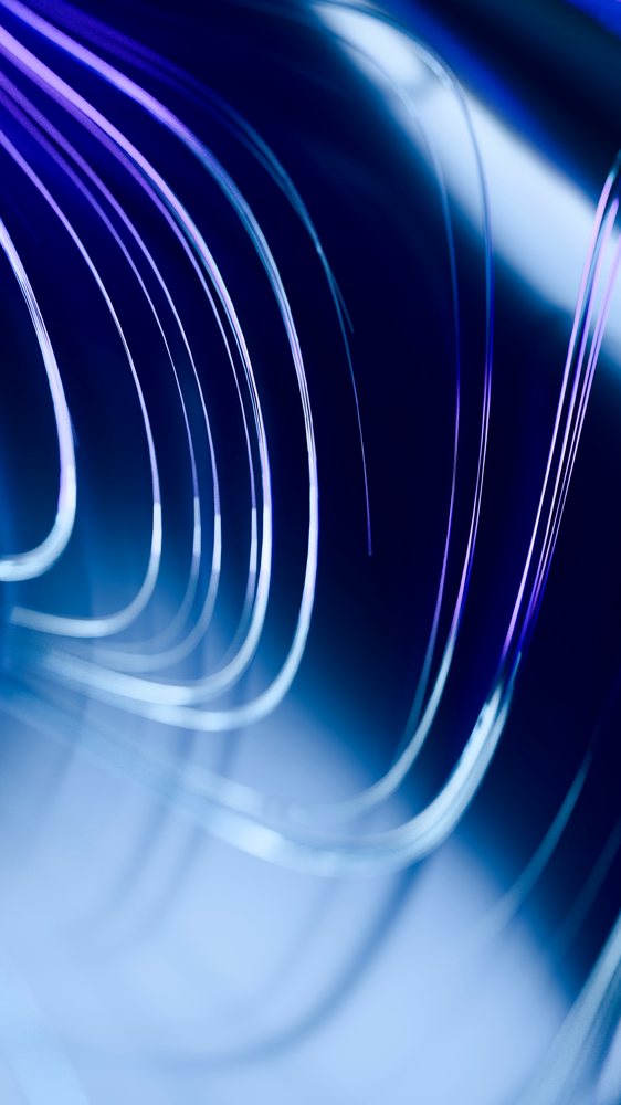 Curved abstract glass elements with blue lighting creating a modern reflective pattern.